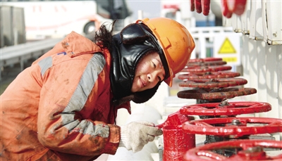 胜利油田石油女工正在维护设备 胜 宣摄